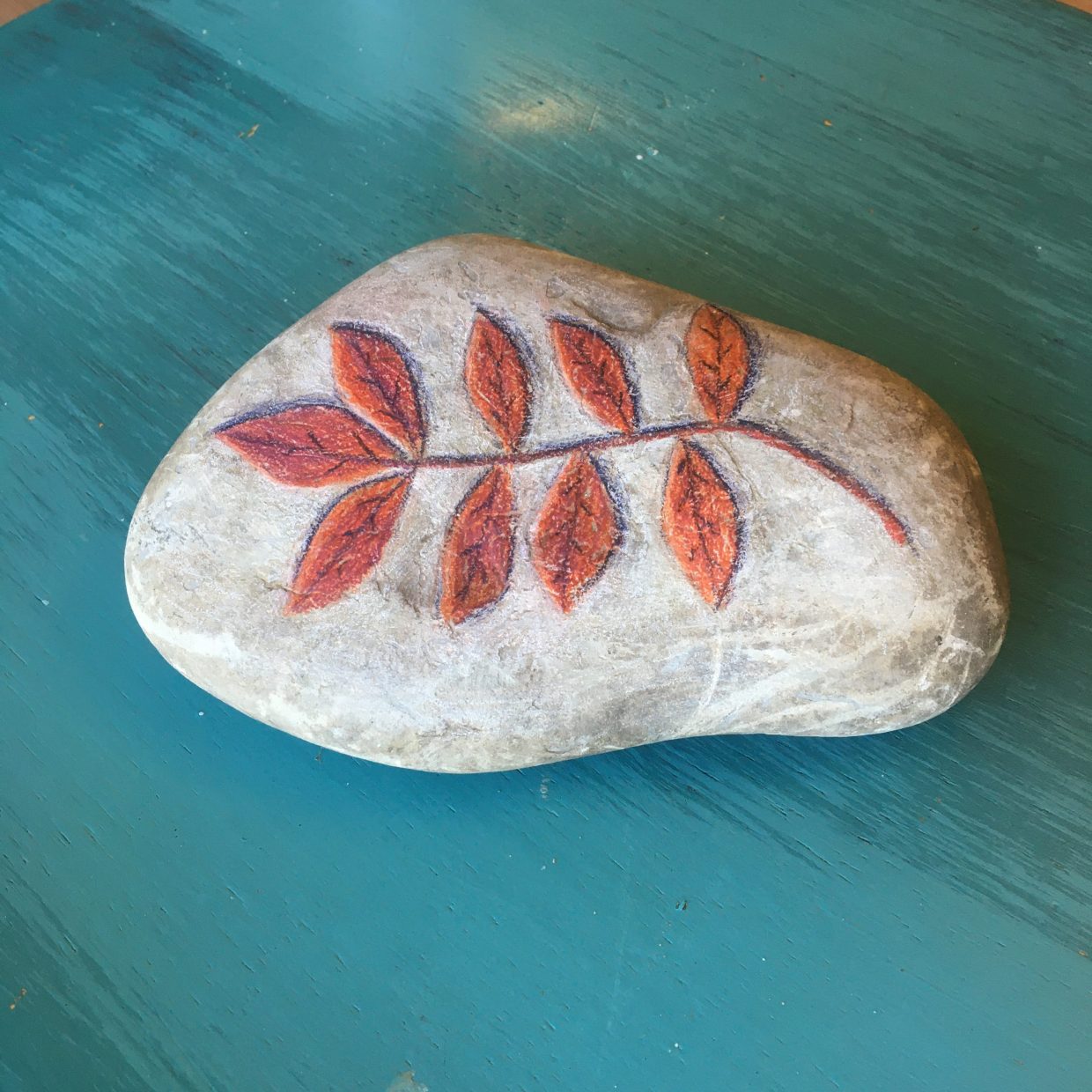 Pencil crayon fall leaf on a rock